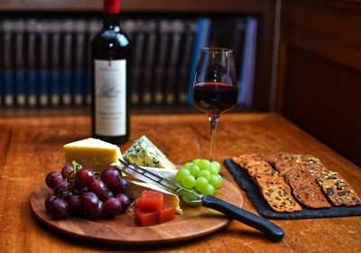 Fruits and wine in glass on table