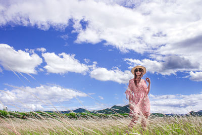 Woman standing on field against sky