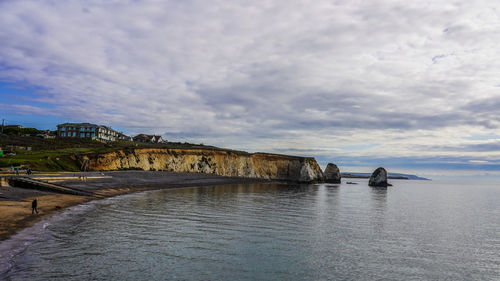Scenic view of sea by buildings against sky
