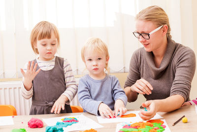 Girls playing with modelling clay at preschool