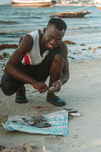 Side view of man sitting on beach