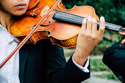 Midsection of man playing guitar at music concert