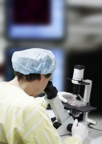 Scientist looking through microscope