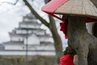 Midsection of woman with red umbrella against building