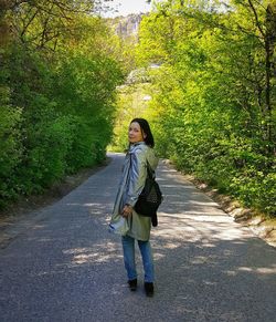 Full length portrait of woman standing on road