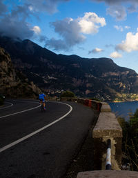 Rear view of man walking on road