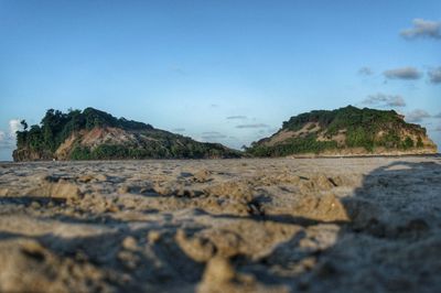 Surface level of rocks on shore against sky