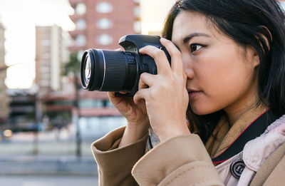 Portrait of woman photographing with camera