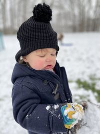 Cute boy eating food outdoors during winter