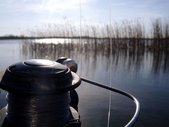 Close-up of ropes in lake against sky