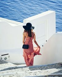 Rear view of woman on steps against sea