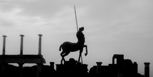 Low angle view of man statue against sky