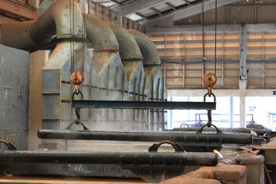 Low angle view of birds perching on industry