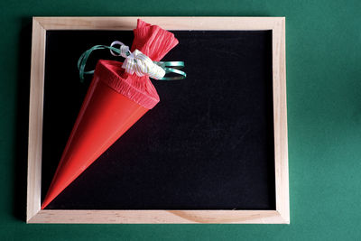 Directly above shot of school cone on slate against green background