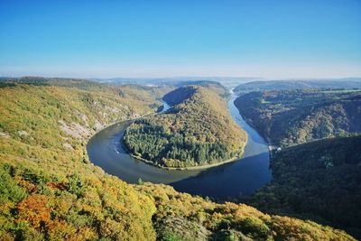 Scenic view of lake and landscape against blue sky