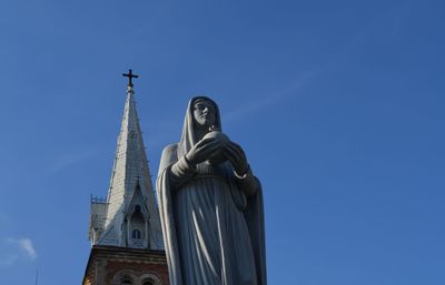 Low angle view of mother mary statue against church