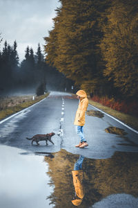 Woman with cat walking on road