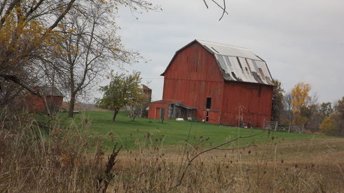 Abandoned house on field against sky