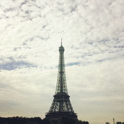 Low angle view of eiffel tower against cloudy sky