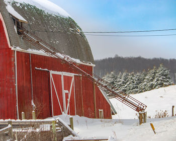 Built structure on snow covered land against sky