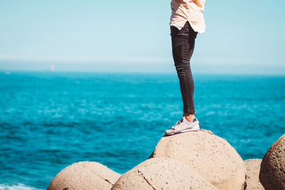 Low section of man standing on beach