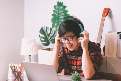 Young woman using phone while sitting on table