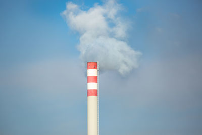 Low angle view of smoke stacks against sky