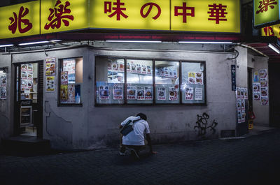 Rear view of woman walking on street against building