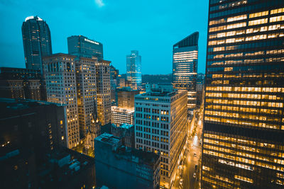 Illuminated buildings in city against sky