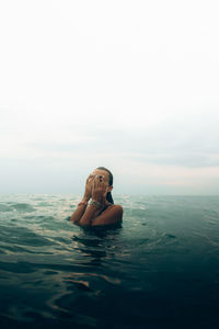 Portrait of women swimming in sea against sky