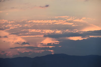 Low angle view of silhouette mountains against dramatic sky