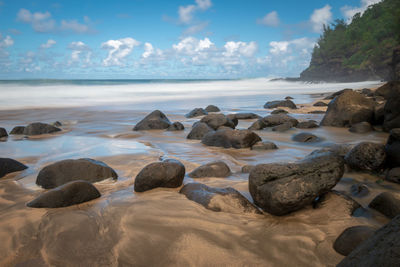 Rocks on beach against sky