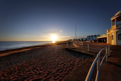 Scenic view of beach against clear sky during sunset