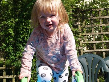 Portrait of girl with blond hair at yard on sunny day