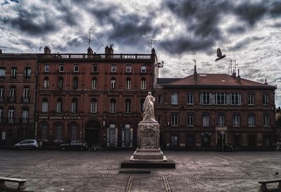 Low angle view of building against cloudy sky