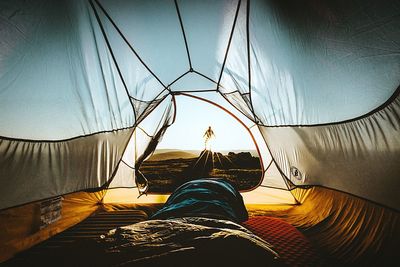 Man standing on rock seen through tent