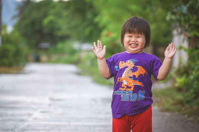 Portrait of happy boy with arms raised