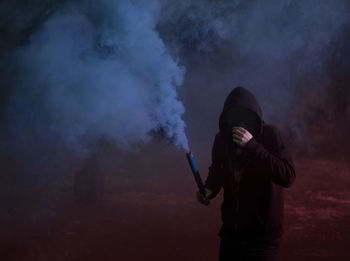 Man standing against sign at night