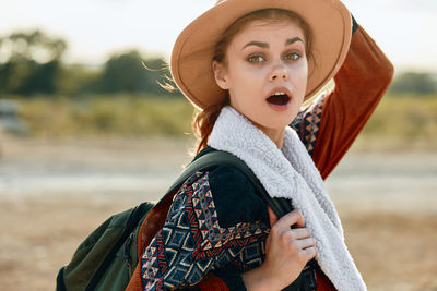 Portrait of smiling young woman standing on field