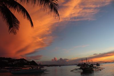 Silhouette boats in sea against sky during sunset