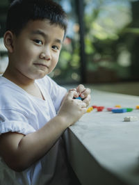 Portrait of cute boy playing with building blocks outdoors