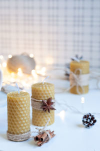 Close-up of burning candles on white background