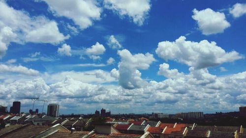 View of cityscape against cloudy sky