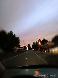 Cars on road against sky seen through car windshield