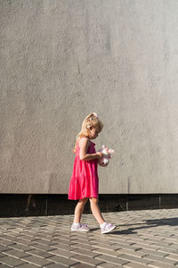 Full length of woman standing against wall