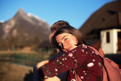 Portrait of smiling woman embracing boyfriend