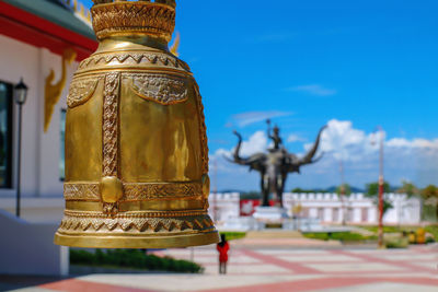  large brass bells of buddhism in temples in pattaya and blue sky background