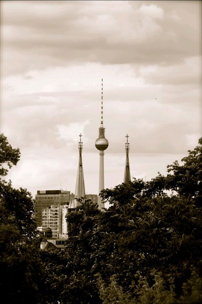 communications tower, tower, built structure, architecture, tall - high, sky, spire, fernsehturm, communication, international landmark, travel destinations, building exterior, cloud - sky, television tower, famous place, capital cities, tourism, culture, low angle view, cloudy