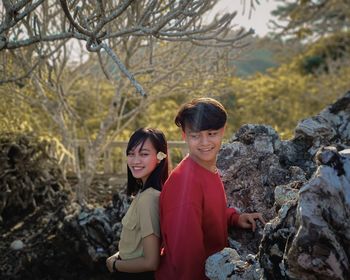 Portrait of smiling young couple standing on old three