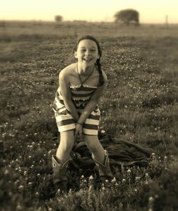 Portrait of young woman standing on field